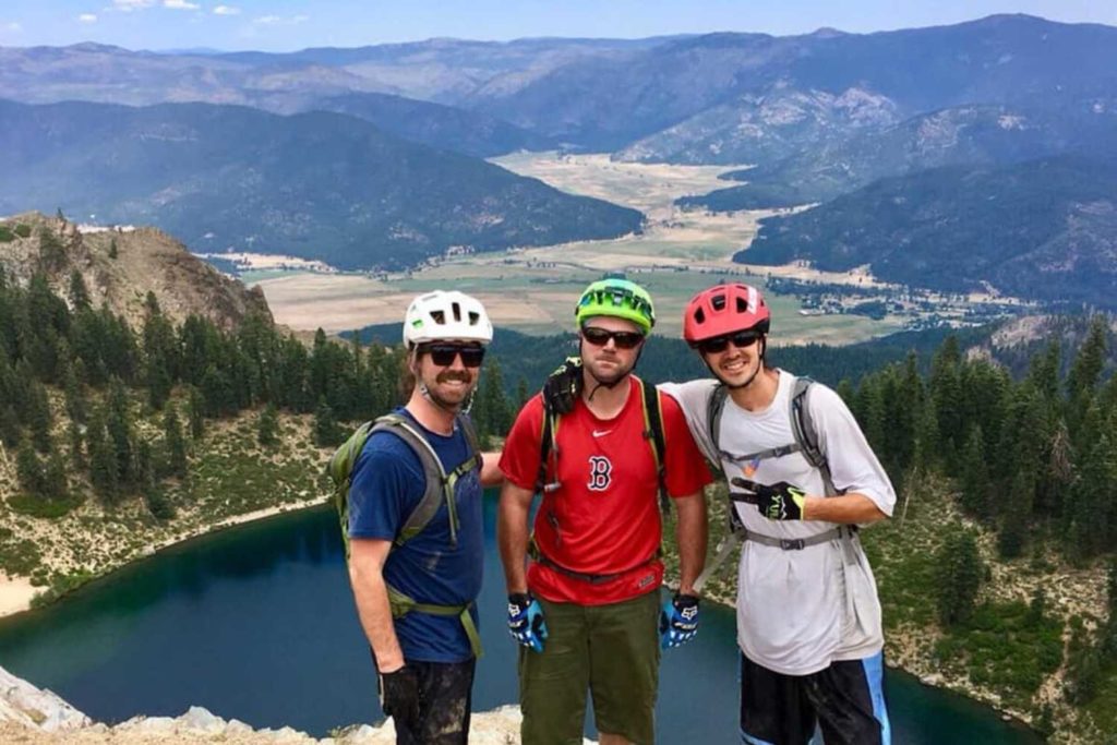 three mountain bikers standing by lake above quincy california