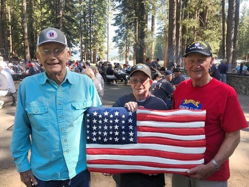 3 Veterans holding the American Flag at the Free Veterans Fishing Day BBQ