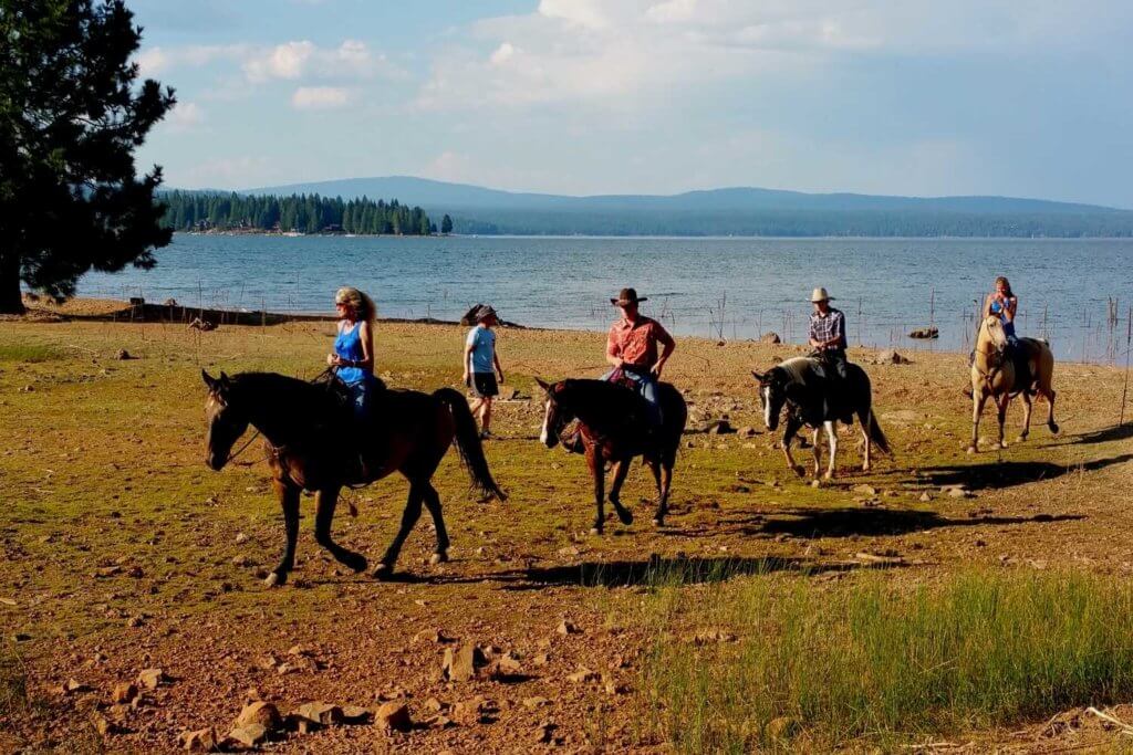 Horses and riders along shore of Lake Almanor