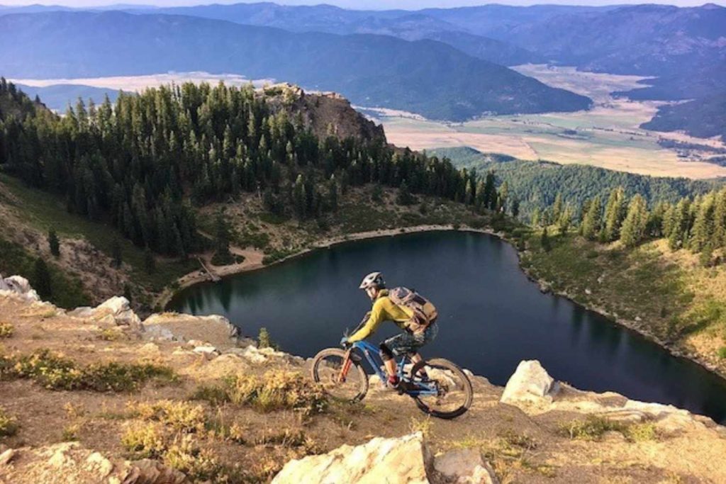 mountain biker on mt hough with lake behind him and american valley near quincy in distance