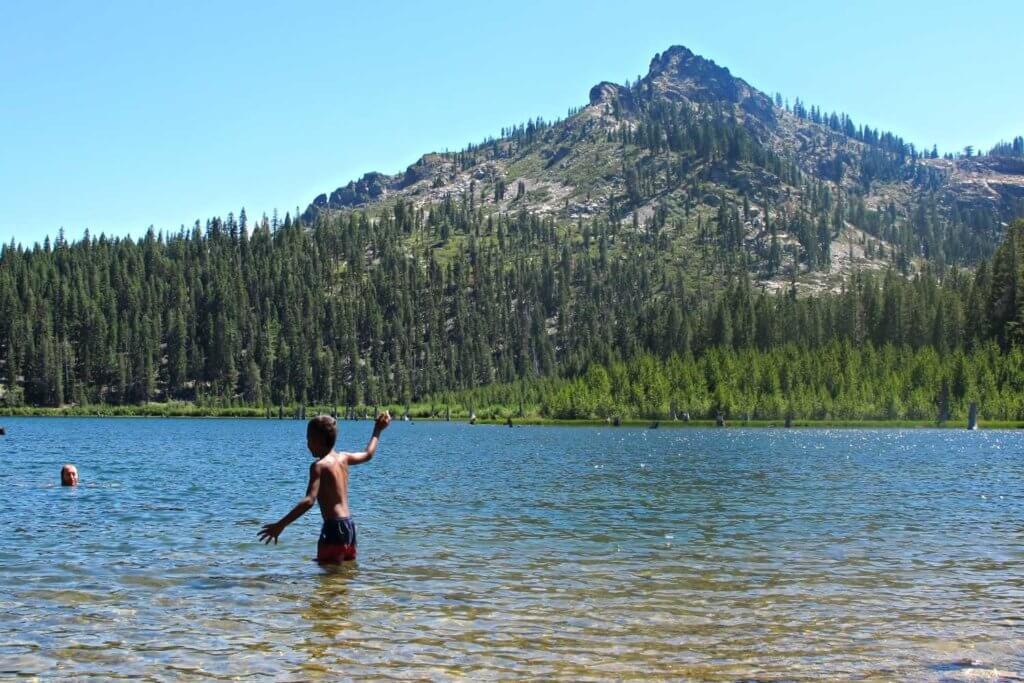 boy in eureka lake with eureka peak in background