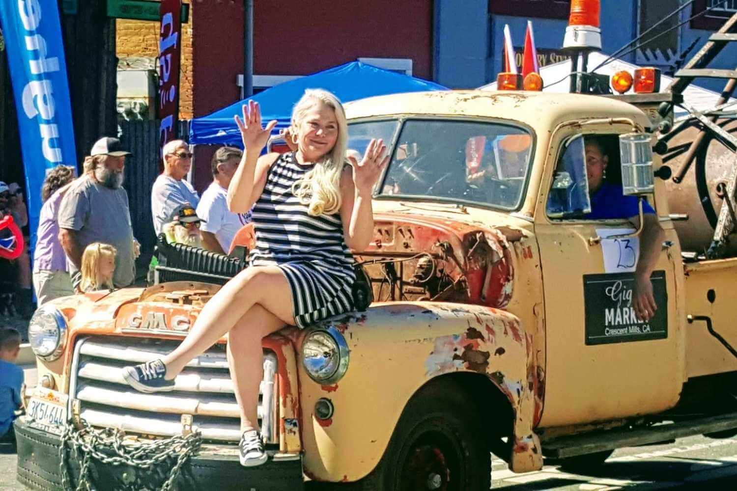 Women sitting on old truck for gold digger day parade