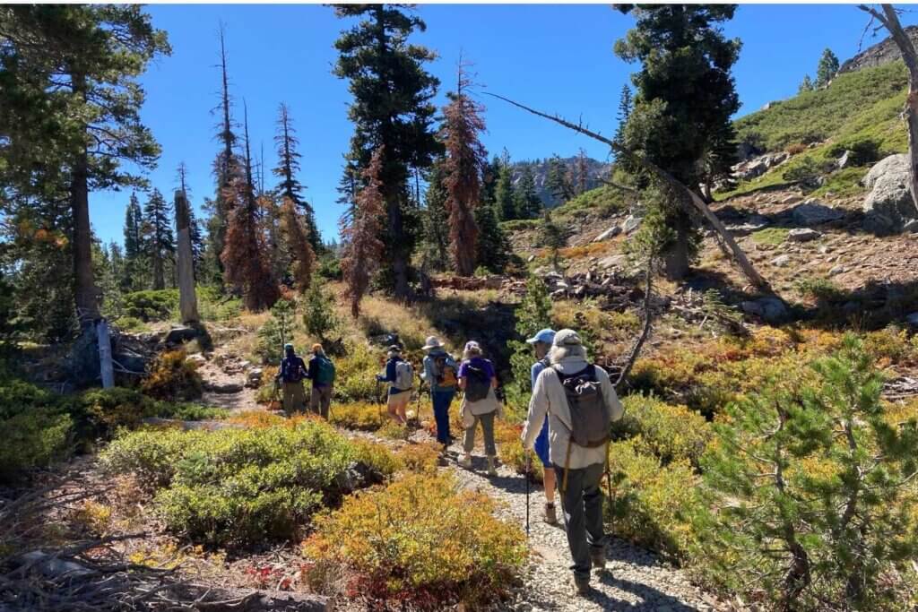 Awesome Autumn begining. Group of hikers on trail to Silver Lake