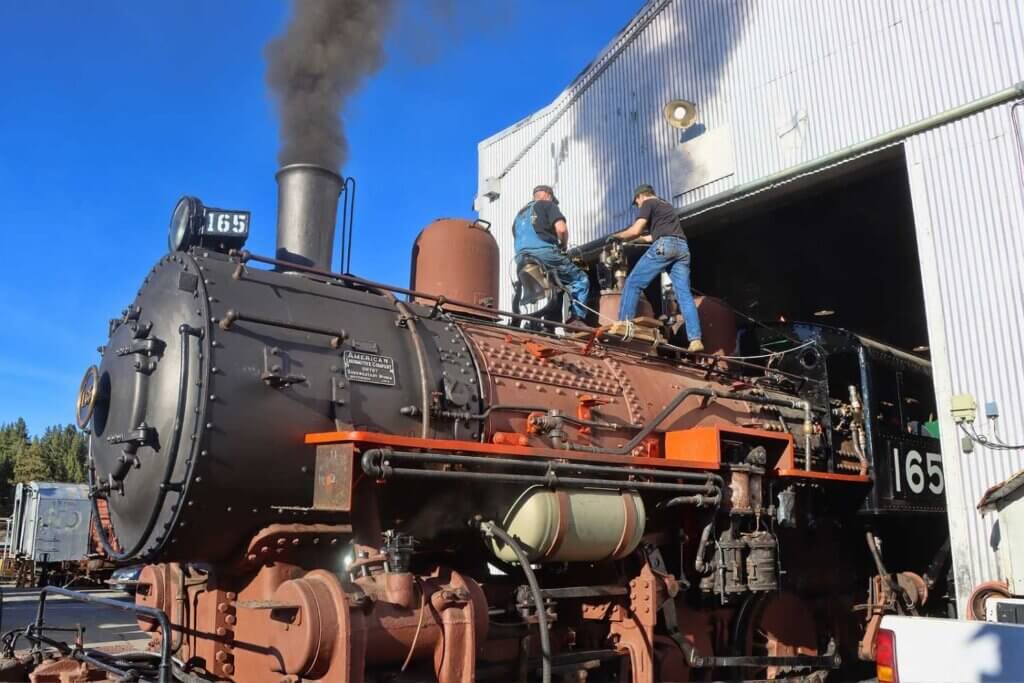 Restored engine with 2 men working on top of it