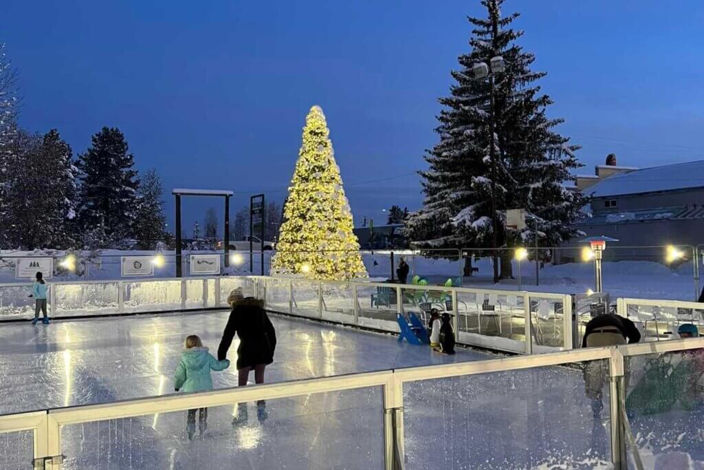 Ice skaters on Chester Ice Skating rink with Community Tree with lights