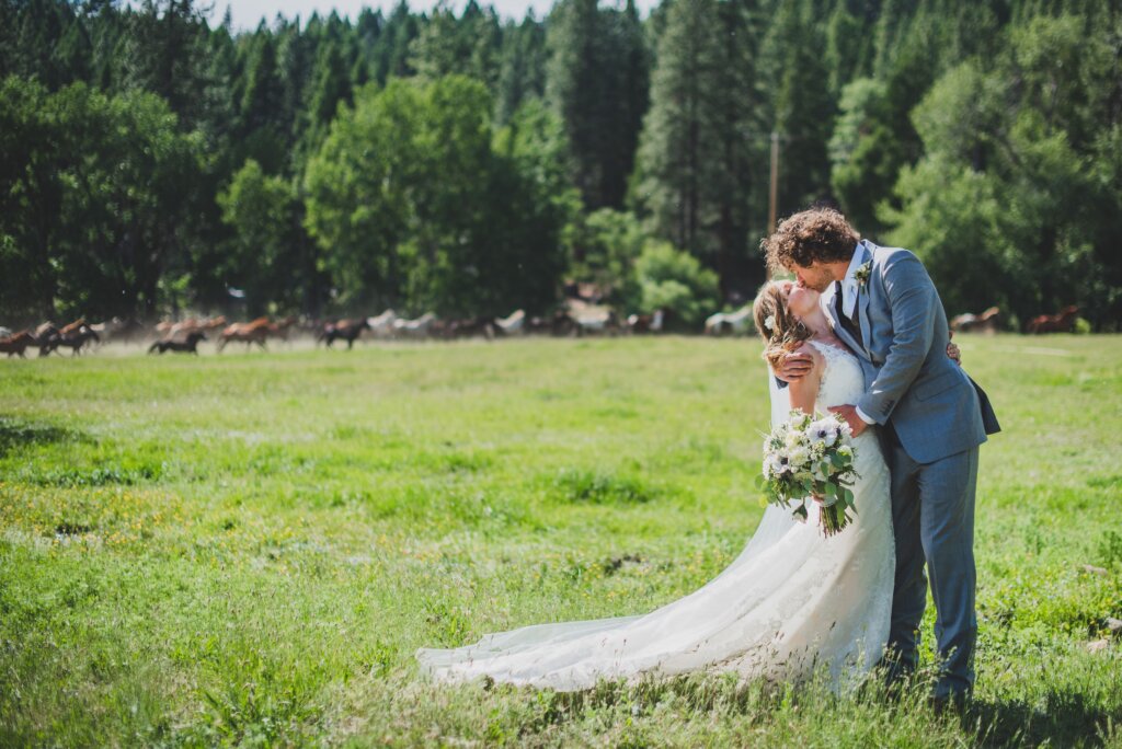 Wedding Couple on the meadow at Greenhorn Ranch with horses in the background