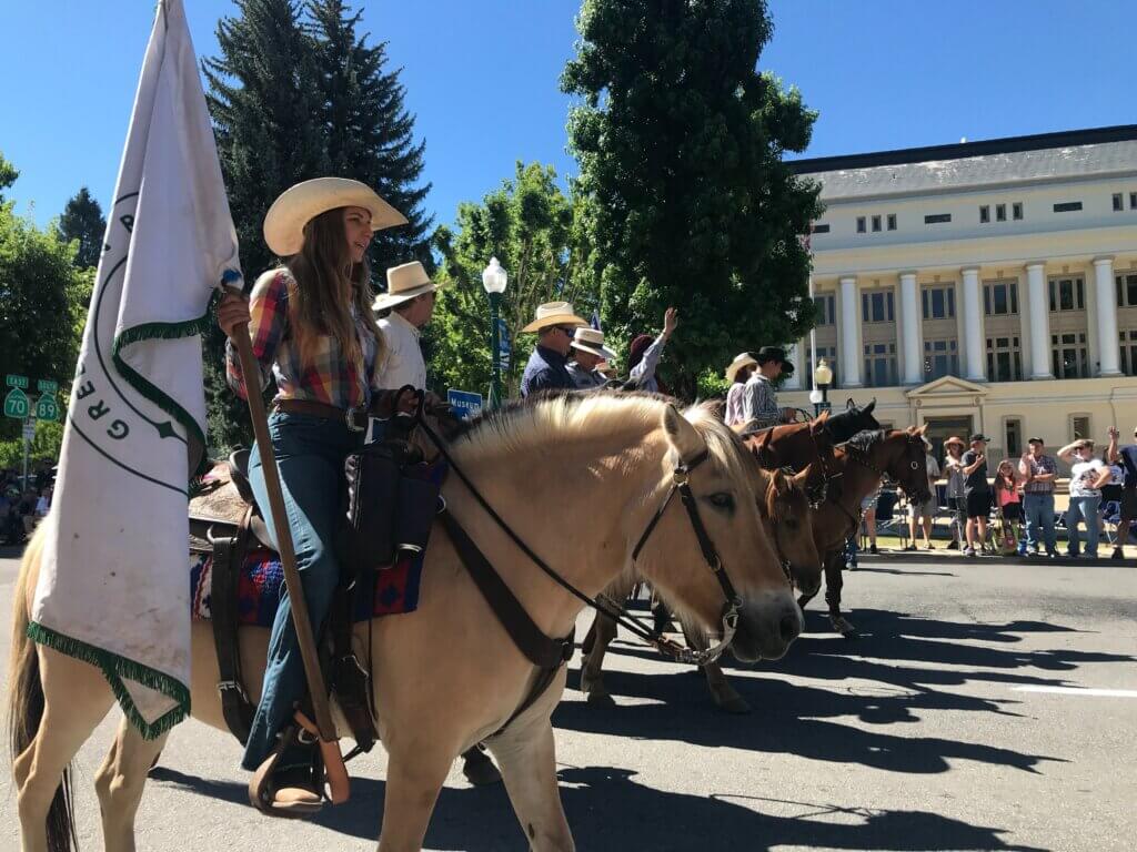 Plumas County Fair Parade Horses with flag in front of Quincy Courthouse
