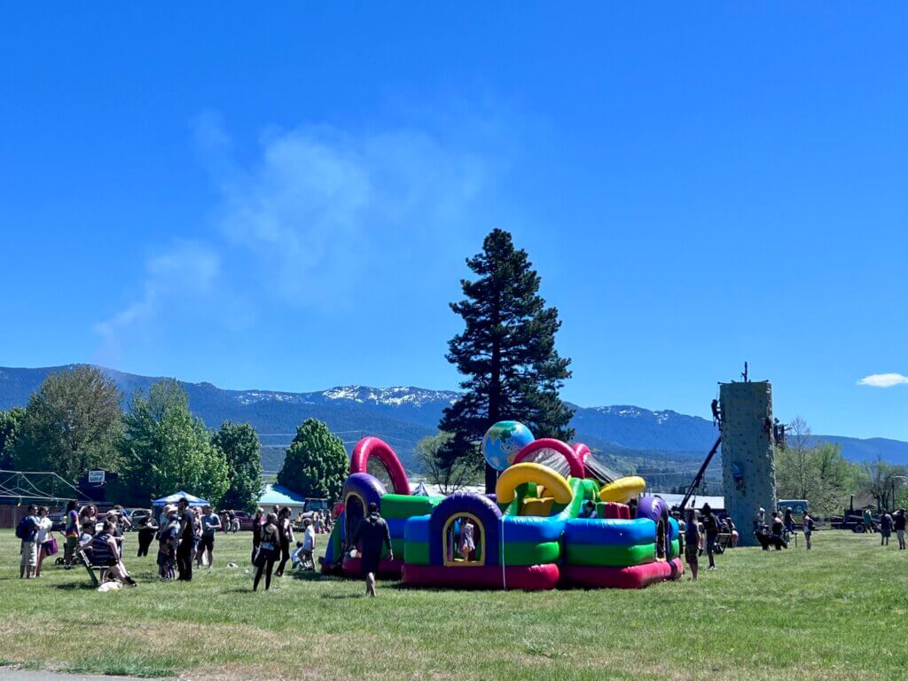 Plumas County Children's Fair. Lawn area wiith bouncy house and people.